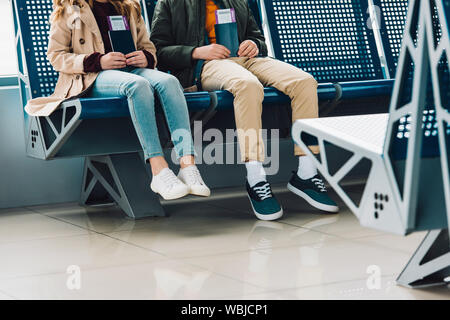 Portrait d'enfants assis sur les chaises bleues et de nationalités dans l'attente de l'aéroport de hall Banque D'Images