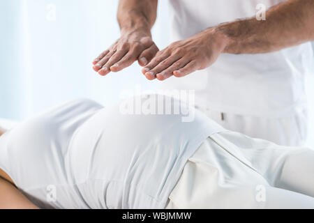 Portrait de guérisseur mettant les mains au-dessus du ventre de femme enceinte Banque D'Images