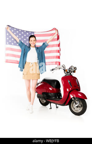 Sur toute la longueur de belle fille debout près de scooter rouge et holding American flag isolated on white Banque D'Images