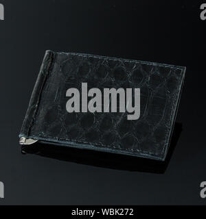 Ensemble de luxe et exotiques fait main pochette de cuir. Artisanat du Cuir. Sur une pierre carreau avec arrière-plan avec Plumeria. La mode serpent Python piton handba Banque D'Images