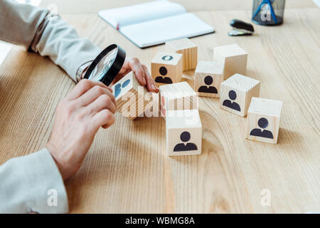 Portrait de recruteur holding magnifier près de cube dans office Banque D'Images