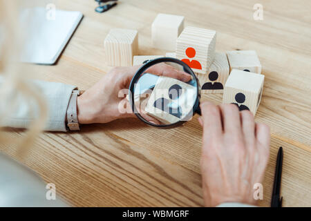 Portrait de recruteur holding magnifier près de cube de bois Banque D'Images