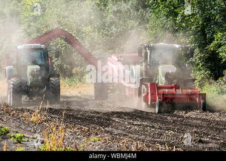 Machines de récolte de pommes de terre à Burscough, Lancashire. UK Météo. Les agriculteurs qui utilisent des tracteurs Fendt 820 et une récolteuse-hacheuse à deux rangs Grimme KSA 75-2 soulèvent une récolte de pommes de terre agricoles alors que les conditions estivales chaudes et sèches et poussiéreuses se poursuivent. Les représentants des agriculteurs avertissent de graves inquiétudes si la vague prolongée de temps chaud et sec se poursuit. Les pommes de terre sont la dernière culture en voie de hausse des prix due à une pénurie causée par un hiver exceptionnellement froid, suivi par un été brûlant. Herbicide, carfentrazone-éthyl est appliqué sur une culture peu avant la récolte pour tuer le feuillage. Banque D'Images