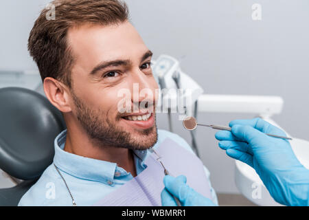 Portrait de dentiste dans des gants en latex tenue près du patient instruments dentaires Banque D'Images