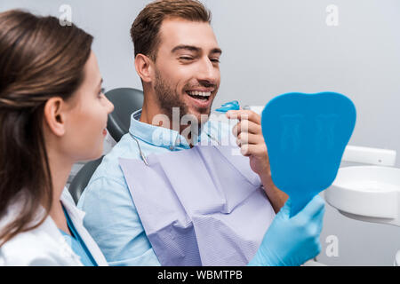 Portrait d'homme heureux à la retenue à miroir et la tenue près de femme Banque D'Images