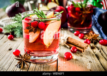 Sangria cocktail chaud d'hiver avec des pommes rouges, du vin, de canneberge, de romarin et d'épices, noël background copy space Banque D'Images
