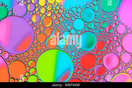 Motifs de bulles multicolores formés par l'huile flottant sur l'eau Banque D'Images