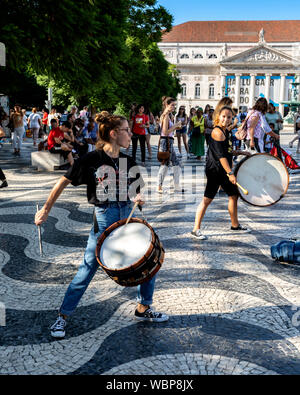 Deux femmes troubadours à jouer de la batterie sur la place Rossio pour les touristes, Lisbonne, Portugal. Banque D'Images