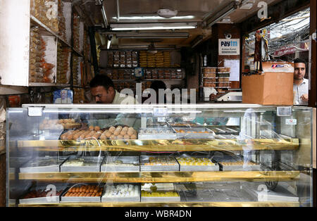 New Delhi, Inde. Août 27, 2019. Un vendeur vend ladoos à un dessert traditionnel shop à New Delhi, Inde, le 27 août, 2019. Ladoo est un Indien sweet habituellement faits de farine, sucre, huile végétale, épices et noix. Il y a beaucoup de magasins vendant des ladoos dessert à New Delhi. Ladoos sont aimés par les habitants, soit comme un plateau snack pour pauses en après-midi ou comme un plat sur des banquets festifs. Credit : Zhang Naijie/Xinhua/Alamy Live News Banque D'Images