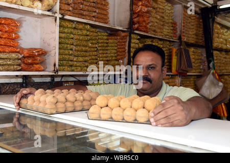 New Delhi, Inde. Août 27, 2019. Un vendeur vend ladoos à un dessert traditionnel shop à New Delhi, Inde, le 27 août, 2019. Ladoo est un Indien sweet habituellement faits de farine, sucre, huile végétale, épices et noix. Il y a beaucoup de magasins vendant des ladoos dessert à New Delhi. Ladoos sont aimés par les habitants, soit comme un plateau snack pour pauses en après-midi ou comme un plat sur des banquets festifs. Credit : Zhang Naijie/Xinhua/Alamy Live News Banque D'Images