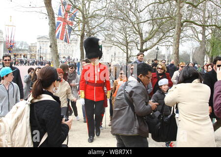 Les touristes à Londres entourent un WELSH OFFICIER DANS LE CENTRE COMMERCIAL PRÈS DE BUCKINGHAM PALACE ET ONT BEAUCOUP DE PLAISIR à interagir avec lui. WELSH GUARDS REGIMENT. Les soldats britanniques. L'UNIFORME DES GARDES. La coiffure DES CINQ Régiments de Gardes BRITANNIQUE EST APPELÉ UN BUSBY OU BEARSKIN. Londres est une destination touristique très populaire avec 51  % DES 39 MILLIONS DE VISITEURS AU Royaume-uni en 2017. L'UNIFORME DE CÉRÉMONIE. CAP BEARSKIN. L'armée britannique. Voyager au Royaume-Uni. Les voyages. CITY BREAKS. La société civilisée. Villes plus sûres. Banque D'Images