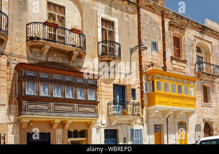 D'un balcon, de style maltais ci-joint, en fer forgé, scène de rue ; vieux bâtiments en pierre calcaire ; Europe ; Birgu, Vittoriosa ; Malte ; printemps ; horizontal Banque D'Images