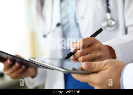 GP féminin faisant des notes électroniques dans tablet pc Banque D'Images