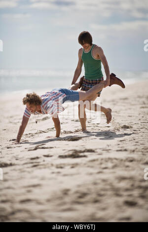 Deux jeunes hommes s'amusant sur la plage. Banque D'Images