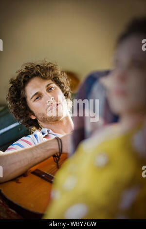 Portrait d'un jeune adulte homme jouant de la guitare. Banque D'Images