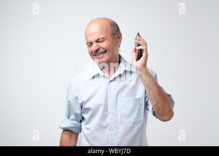 Caucasian man est irrité avec conversation téléphonique. Studio shot Banque D'Images