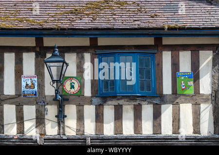 Signes et ancienne lampe de rue sur un bâtiment en bois à Winchcombe, Cotswolds, Gloucestershire, Angleterre Banque D'Images