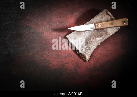 Tête de hache et battues nouveau couteau de cuisine sur fond noir-rouge foncé with copy space Banque D'Images