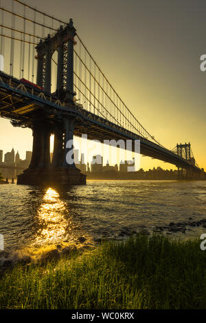 New York, vue du pont de Brooklyn au coucher du soleil de pont de Manhattan avec la skyline de Manhattan dans la distance, New York City, USA Banque D'Images