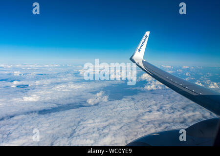 Vue depuis un avion fenêtre affichant le logo de l'ailette avec Ryanair. Au-dessus des Alpes, l'Europe. Banque D'Images