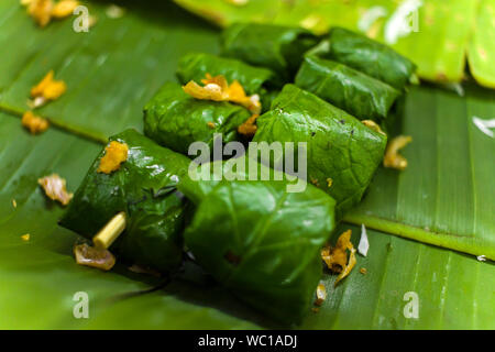 Dessert thaï riz collant, le lait de coco et de bananes enroulées dans des feuilles de bananier galerie d'images haute résolution. Banque D'Images