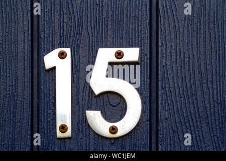 Silver house numéro 15 sur un porte en bois noir Banque D'Images