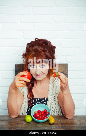 Senior woman smile avec Apple et de fraise, de vitamine Banque D'Images