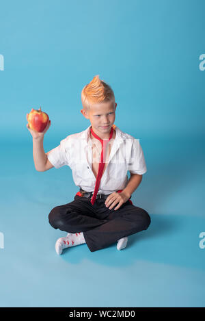 Close-up d'un garçon blond.Le garçon pose sur l'appareil photo. Il est charmant.petit écolier.Professeur dans une école uniforme avec une chemise blanche et noire pa Banque D'Images