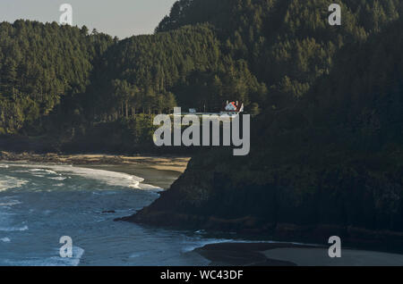 Sur la côte de l'Oregon, se dresse au sommet du phare de Heceta Head falaises surplombant une plage isolée, vu de l'US 101, la côte du Pacifique Scenic Byway. Banque D'Images