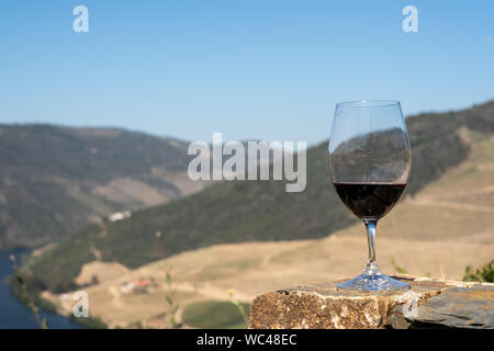 Verre de vin rouge au-dessus de la vallée du fleuve Douro au Portugal Banque D'Images