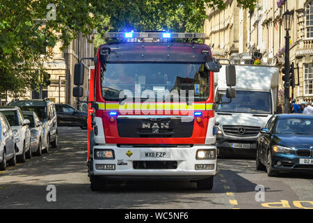 BATH, ANGLETERRE - Juillet 2019 : Fire Engine bleu avec les clignotants, roulant sur une route à grande vitesse sur un appel d'urgence dans le centre de Bath. Banque D'Images