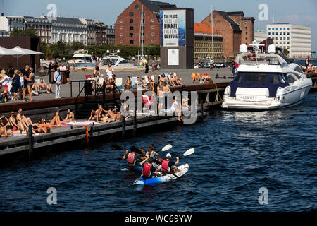 Copenhague et les touristes à l'embarcadère en bois de la plage Ofelia, près du Royal Play House et de l'historique Nyhavn à Copenhague, Danemark. L'eau dans le port de Copenhague est si propre qu'il est sûr de prendre un plongeon. En 2018, Copenhague a été en tête de liste de CNN pour les « meilleures villes pour nager ». Banque D'Images