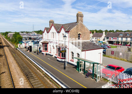 Passagers attendant leur train pour arriver à la gare de Llanfairpwllgwyngyllgogerychwyrndrobwllllantysiliogogogoch sur le Nord du Pays de Galles Banque D'Images