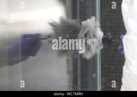 Close-up de l'agent de police de mains porter des gants de poudre pour les empreintes digitales Banque D'Images