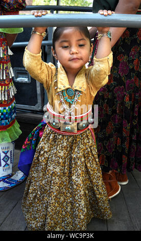 Une jeune fille Navajo pose pour une photo avant de participer au concours de vêtements autochtones le marché indien de Santa Fe de Santa Fe, Nouveau Mexique. Banque D'Images