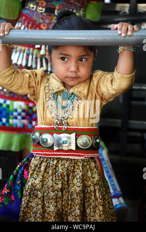 Une jeune fille Navajo pose pour une photo avant de participer au concours de vêtements autochtones le marché indien de Santa Fe de Santa Fe, Nouveau Mexique. Banque D'Images