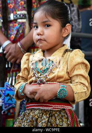 Une jeune fille Navajo pose pour une photo avant de participer au concours de vêtements autochtones le marché indien de Santa Fe de Santa Fe, Nouveau Mexique. Banque D'Images