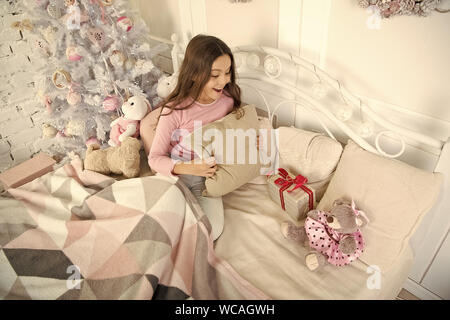 Petite fille se détendre à la maison. Noël famille vacances. bonne année. Les achats de Noël. petit enfant fille avec cadeau de Noël. Le matin avant Noël. Le Sommeil. en attente de santa. L'hiver. Regarder ça. Banque D'Images