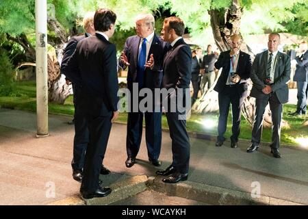 Le Président américain Donald Trump, centre s'entretient avec le Premier ministre britannique, Boris Johnson, à gauche, et le président français, Emmanuel Macron, droite, suite au G7 Leaders' Dîner au phare de Biarritz, 24 août 2019 à Biarritz, France. Banque D'Images