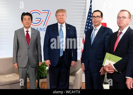 Le Président américain Donald Trump, centre, avec le Premier ministre japonais Shinzo Abe, à gauche, le secrétaire du Trésor américain Steve Mnuchin et Chef de Cabinet de la Maison Blanche Mick Mulvaney, droit, avant leur réunion commerciale en marge de sommet du G7 au centre de congrès Bellevue 25 août 2019 à Biarritz, France. Banque D'Images