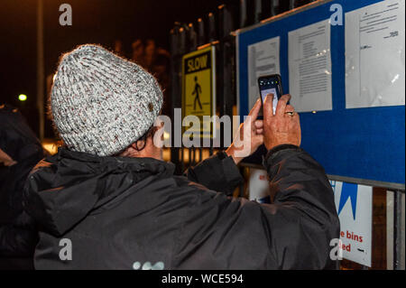 Bandon, West Cork, Irlande. 27 août 2019. Un groupe d'agriculteurs a repris ce soir leur protestation devant ABP Bandon, malgré une injonction du tribunal. Les agriculteurs sont mécontents des pourparlers qui ont eu lieu la semaine dernière et demandent au ministre Michael Creed d'intervenir dans l'impasse des prix. L'injonction du tribunal est affichée à l'extérieur des portes de l'usine, mais elle est établie à Beef Plan, et non à des agriculteurs individuels. Les agriculteurs disent qu'ils sont là pour le long terme. Une agricultrice photographie l'injonction. Crédit : AG News/Alay Live News Banque D'Images