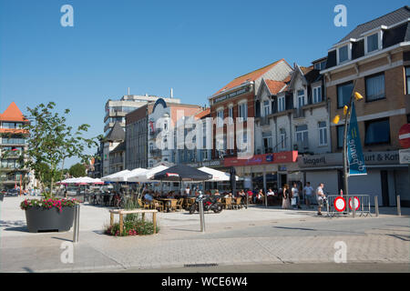 Les visiteurs et les habitants bénéficiant d'un repas et ou un verre tout en assis dehors sur une journée ensoleillée à la place du marché de De Panne, Belgique Banque D'Images