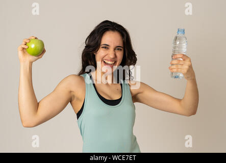 Remise en forme Happy woman smiling tenant une pomme et une bouteille d'eau se sentir fort et sain. En mode de vie sain, d'entraînement et la nutrition concept. Portrai Banque D'Images