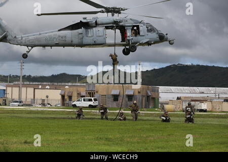 Les Marines américains avec 3e Bataillon de Reconnaissance, 3e Division de marines, conduite suspension corde d'hélicoptères de formation un hélicoptère Seahawk MH-60S HYDRACRAB au cours de l'exercice à Santa Rita, Guam, le 19 août 2019. HYDRACRAB est un exercice multilatéral mené par les Marines américains et les marins avec les membres du service militaire de l'Australie, le Canada et la Nouvelle-Zélande. Le but de cet exercice est de préparer les forces de destruction des engins explosifs pour fonctionner comme un système intégré, capable, efficace et allied force prêts à fonctionner dans un environnement maritime changeant et complexe tout au long de l'Indo-P Banque D'Images