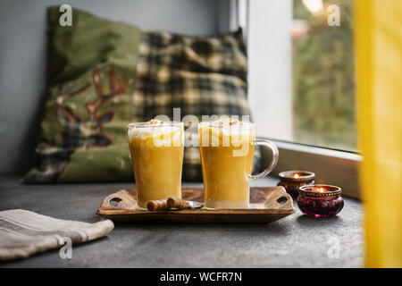 Deux tasses en verre de pumpkin spice latte près d'une fenêtre Banque D'Images