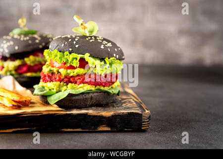 Deux hamburgers avec noir vegan patates frites Banque D'Images