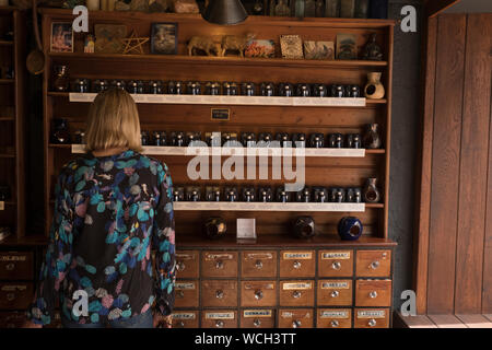 Femme dans magasin de potions dans le centre du village de Glastonbury dans le Somerset en été Banque D'Images