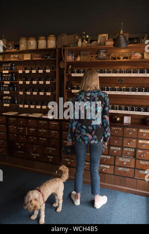 Femme en boutique dans le centre du village de Glastonbury dans le Somerset en été Banque D'Images