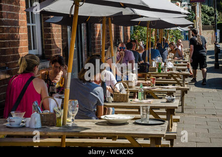 Les gens s'asseoir à l'extérieur à l'extérieur d'une des tables à tréteaux gastro pub à Marlow, dans le Buckinghamshire, Royaume-Uni Banque D'Images