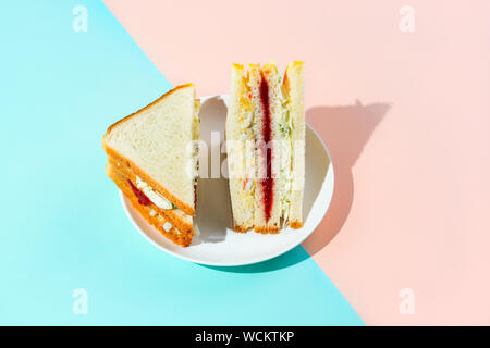 Sandwich coréen branché inkigayo associé à k-pop culture sur une plaque blanche sur deux couleurs pastel arrière-plan, l'orientation horizontale, tourné avec disque Banque D'Images